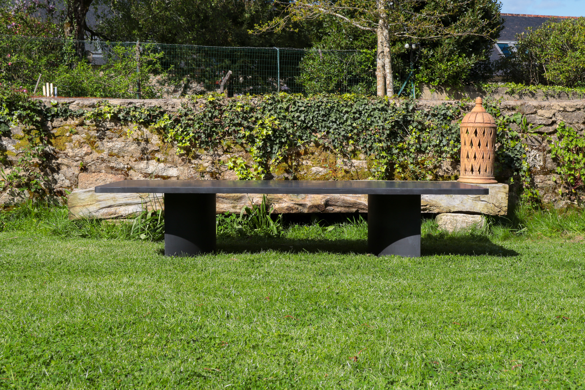 Table basse Carmen en béton noire, minéralisé et noirci, elle donne une touche moderne au jardin. Elle est designé par Carmen Maurice Architecte.